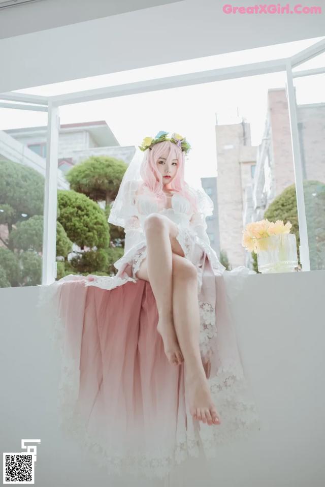 A woman in a wedding dress sitting on a window sill.