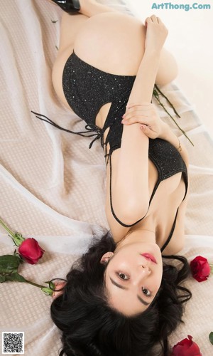 A woman in a pink lingerie holding a rose.