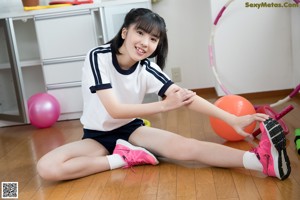 A young girl is playing with a hula hoop.