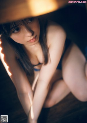 A woman in a black tank top laying on the ground.