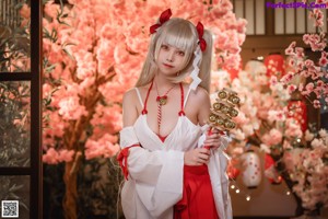 A woman in a red and white kimono holding a sword.