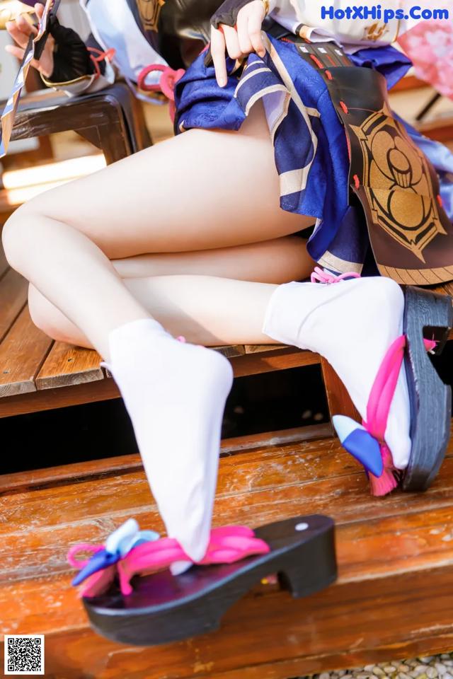 A woman sitting on a wooden bench holding a cell phone.