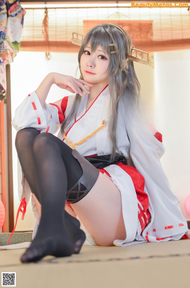 A woman in a kimono sitting on the floor.
