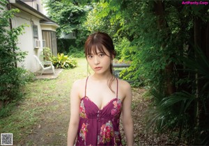 A woman in a black lingerie holding a red rose.
