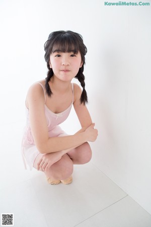 A woman in a pink bodysuit posing for a picture.