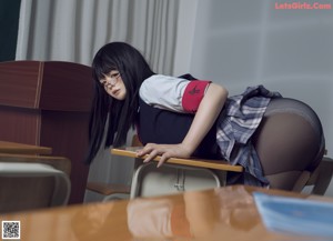 A woman in a school uniform is sitting on a desk.