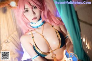 A woman with pink hair is posing for a picture.