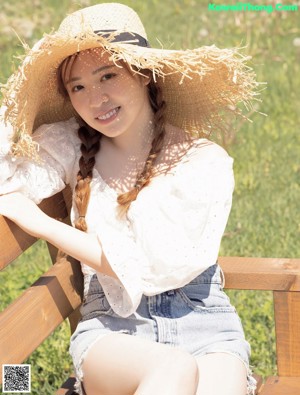 a woman in a straw hat is posing for the camera