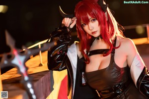 A woman dressed as a devil holding a sword.