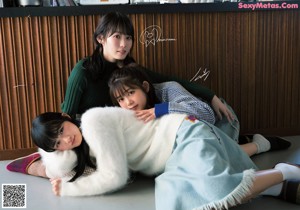 A group of young women sitting on top of a bed.