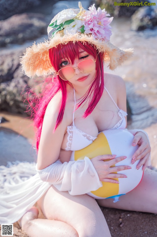 A woman with pink hair wearing a straw hat and sunglasses.