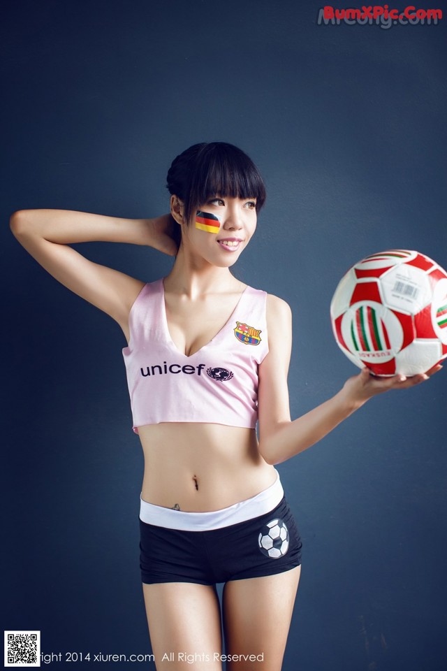 A woman holding a soccer ball in her hands.