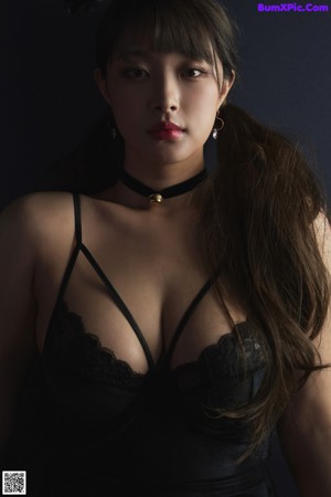 A woman in a black lingerie posing for a picture.