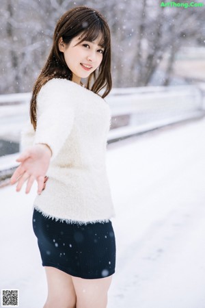 A woman in a white sweater is posing for a magazine cover.