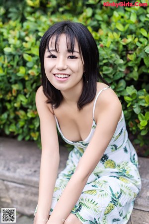 A woman in a white dress posing for a picture.