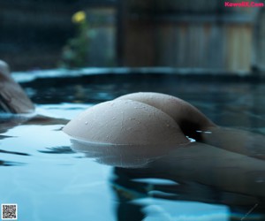 A woman with wet hair standing in a hot tub.
