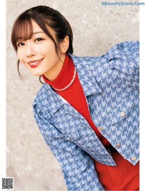 a woman in a blue jacket and red pants posing for a picture