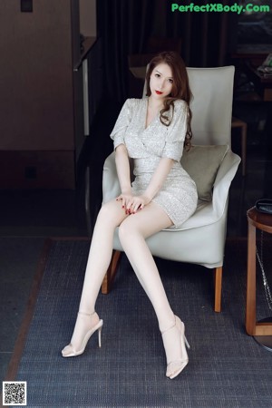 A woman sitting on a couch in a room.