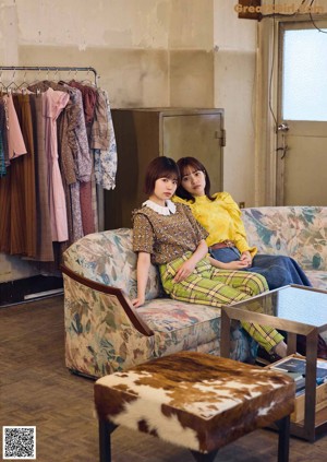 A couple of young women laying on top of a bed.