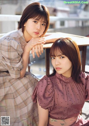 Two women sitting on a couch in a clothing store.