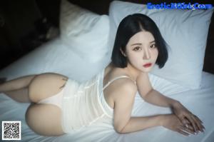 A woman in a white lingerie sitting on a counter.
