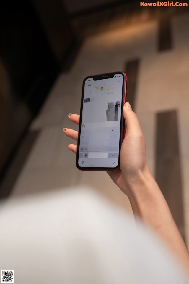 A person holding a smart phone with a keyboard on the screen.