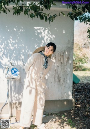 A woman in a blue and white kimono standing in front of a lake.