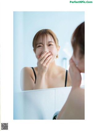 A woman with her eyes closed and her hands on her face.