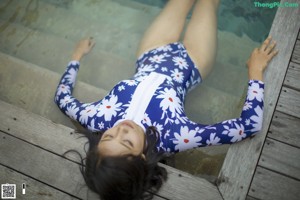 A woman standing in front of a swimming pool.