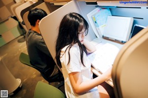 A man and a woman wearing face masks in a library.